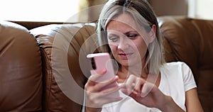 Portrait of young smiling woman holding mobile phone typing text message