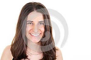 Portrait of young smiling woman looks in camera over white wall copy space background