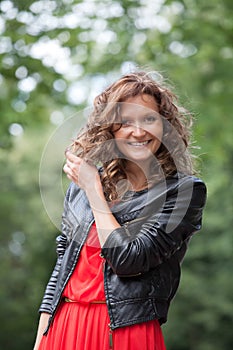 Portrait of young smiling woman in park.