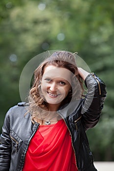 Portrait of young smiling woman in park.