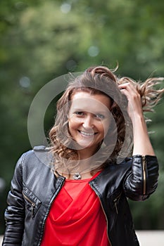 Portrait of young smiling woman in park.