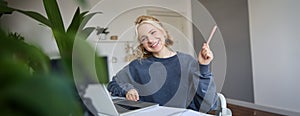 Portrait of young smiling woman, student talking to teacher online via video chat, doing course, attends remote course