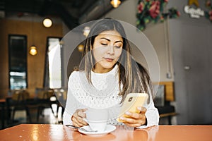 Young woman using a phone in a coffee shop
