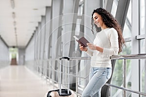 Portrait Of Young Smiling Woman Waiting For Flight In Airport Terminal,