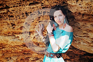 Portrait of a young smiling woman wearing dreadlocks hairstyle, dressed in blue lace dress and blue boho chic earrings