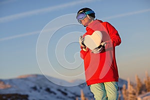 Portrait of young snowboarder girl with snow heart in hands