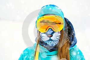 Portrait of young snowboarder girl in snowboard goggles.