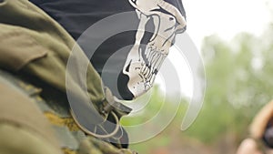 Portrait of young soldier in military uniform with cloth mask on his face. Sports game using a copy of a firearm. Close