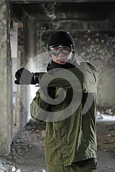 Portrait of young soldier pointing with gun