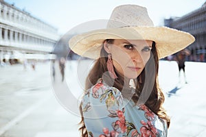 Portrait of young solo traveller woman in floral dress with hat photo