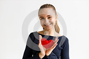 Portrait of a young sports girl with a heart in her hands, endurance training. Cardiology health