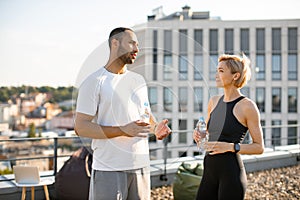 Portrait of young sportsman and fit woman in sportswear resting after running.