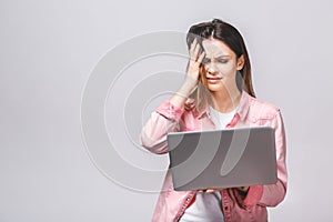 Portrait young stressed displeased worried business woman with laptop computer isolated over white background. Negative face