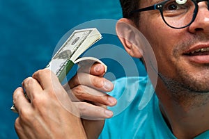 Young stylish man counting heaps of money