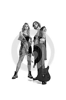 Portrait of young stylish man and woman, rock and roll musicians posing over white background. Guitar player and singer