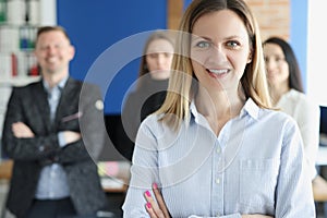 Portrait of young successful business woman on background of colleagues