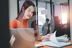 Portrait of Young Successful Caucasian Businesswoman sitting at desk working on laptop computer.