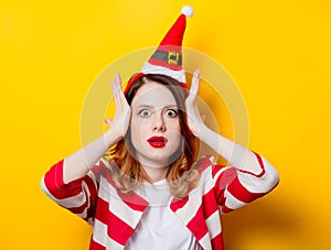 Portrait of young surprised redhead woman in Santa Claus hat
