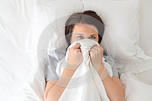 Portrait of young surprised woman in bed