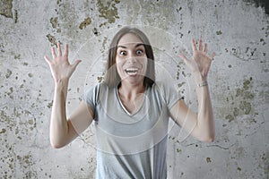 Portrait of young surprised woman with opened mouth standing with open palms