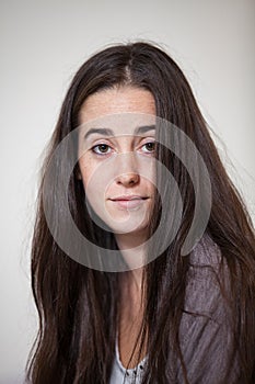 Portrait of a young and sweet natural woman without makeup with long brown hair