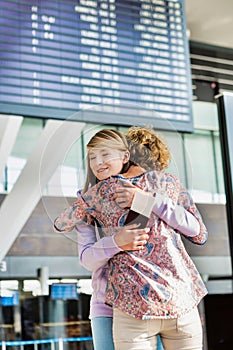 Portrait of young teenage girl reunting with her mother in airport