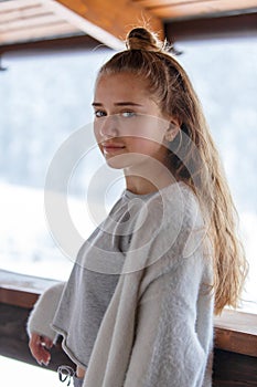Portrait of young teenage girl in warm cozy clothes at the terrace