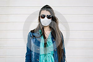 Portrait of a young teenage girl wearing a clinical mask so as not to become infected by respiratory tract. News of the covid-19