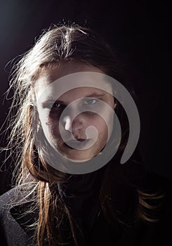 Portrait of young teenager brunette girl with long hair in the Gothic style, on a black