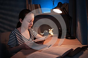 portrait of a young teenager junior school student studying at home in evening. homeschooling. distance education