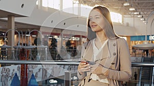 Portrait of a young teenager tourist woman visiting the city shopping using her smartphone device and smiling. Business