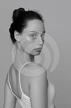 Portrait of young tender girl with no makeup posing, looking at camera. Black and white photography