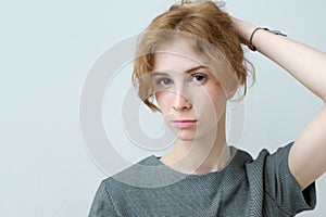 Portrait of young tender redhead teenage girl with healthy freckled skin wearing official dress looking at camera