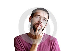 Portrait of the young thinking man looks up with hand near face - isolated on white