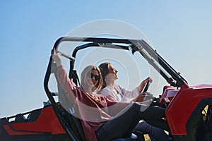 girls enjoying a beautiful sunny day while driving an off-road car