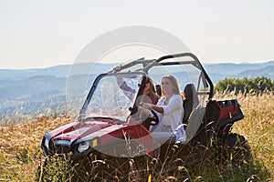 girls enjoying a beautiful sunny day while driving an off-road car
