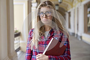 Portrait of a young unhappy student girl in natural light. Dress