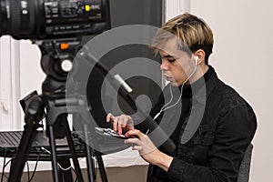 Portrait of a young video engineer 20-25 years old, conducts an online broadcast on the Internet.
