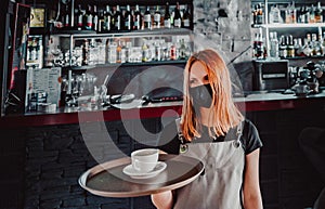 Young waitress standing in cafe. girl the waiter holds in bunches a tray with utensils. Restaurant service
