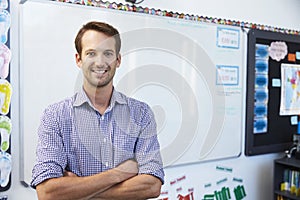 Portrait of young white male teacher in school classroom