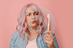 Portrait of young woman with aching teeth, pain in sensitive bleeding gums, brushing teeth. Dental care