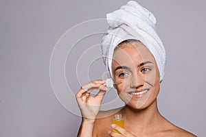 Portrait of a young woman applying hyaluronic acid in a studio. photo