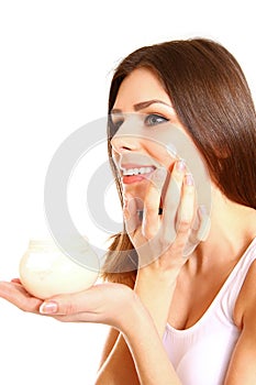 Portrait of young woman applying moisturizer cream on her pretty