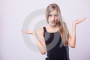 Portrait young woman arms out shrugs shoulders asking isolated grey wall background.