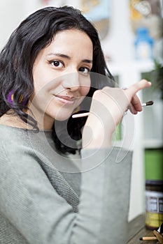 Portrait of young woman artist holding a brush in her hand