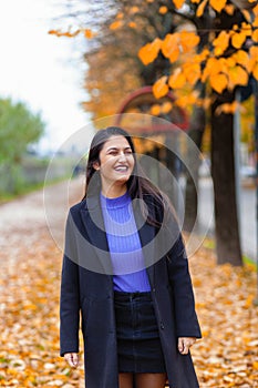 Portrait of a young woman in autumn. She laughs, authentic moment