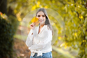 Portrait of young woman with autumn leafs. Romantic girl dream, hold fall maple leaves. Autumnal season.