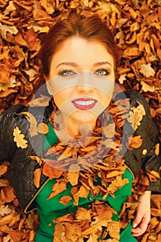 Portrait of young woman in autumn leaves.