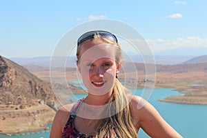 The portrait of young woman on the Barrage Al massira, big water storage in Morocco, background.