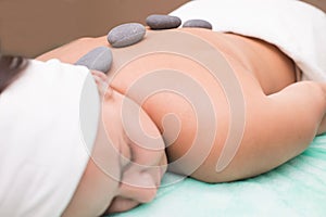 Portrait of a young woman blissfully enjoying spa therapy. close-up. Massage stones